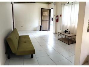 巴科洛德OYO 800 Ddd Habitat Dormtel Bacolod的客厅配有绿色沙发和桌子