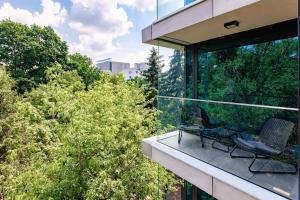 卢布林Apartamenty Premium NJ Lublin Centrum Basen & SPA的大楼内的阳台配有两把椅子和树木