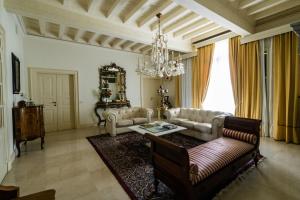 代森扎诺-德尔加达Villa San Pietro的带沙发、桌子和吊灯的客厅