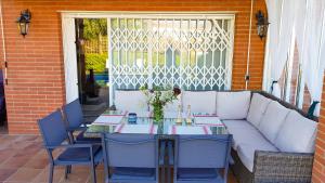 滨海阿雷尼斯Stay U-nique Villa Portimar的庭院里配有一张带白色沙发和椅子的桌子