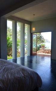 纳闽巴霍蓝鹦鹉酒店的一间卧室设有一张床和一个大型玻璃门