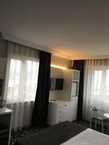 班德尔马埃肯声望酒店的酒店客房设有一张床、一台电视和窗户。
