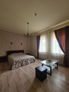 VabalninkasMeldynas的一间卧室配有一张床和一张玻璃桌