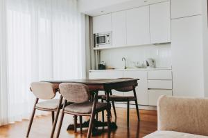 里斯本54 São Paulo - Exclusive Apartment Hotel的厨房配有木桌和椅子