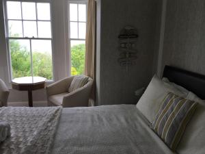 卡比斯贝Borthalan House的卧室配有床、椅子和窗户。