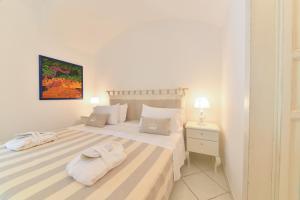 伊斯基亚Queen Suite - Luxury Rooms的一间白色卧室,床上配有2条毛巾