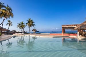 伊斯塔帕伊斯塔帕全包假日酒店度假村的棕榈树海滩旁的游泳池