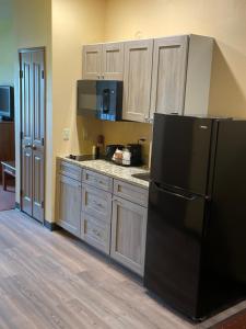 法戈AmericInn by Wyndham Fargo Medical Center的厨房配有黑色冰箱和木制橱柜。