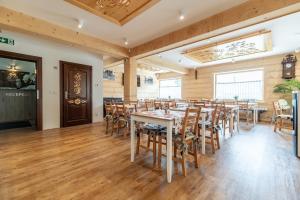 乔乔洛Stachelisko - domki i pokoje的餐厅铺有木地板,配有桌椅
