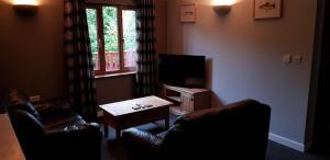 布里奇沃特Walnut Lodge, Summerhayes的客厅配有2把皮椅和电视