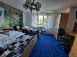 JesionkaPENSJONAT KAPRYS的一间卧室设有两张床、一张桌子和一个窗口。