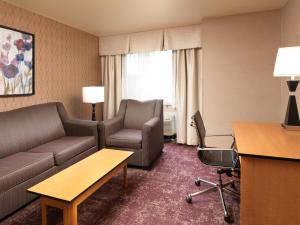 西瓦利城Crystal Inn Hotel & Suites - West Valley City的酒店客房设有沙发和桌子