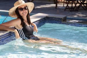 布希奥斯鲍萨达阿瓜斯克拉斯酒店的戴帽子的女人在游泳池里