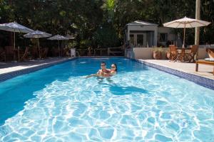 布希奥斯鲍萨达阿瓜斯克拉斯酒店的男女在游泳池游泳