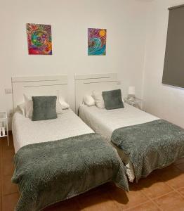 拉桑塔Apartamento los Rostros的墙上画作的房间里设有两张床