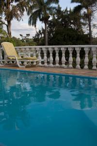 贝洛奥里藏特Pousada Lagoa的一个带椅子的游泳池,靠近围栏