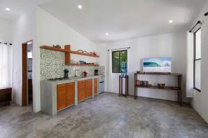 里瓦斯Zen Casita + Studio的厨房设有白色的墙壁、木制橱柜和窗户。