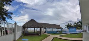 查察拉卡斯Hotel Perlas del Golfo的一个带稻草屋顶和围栏的亭子