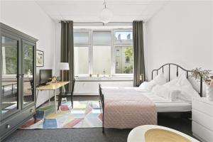 柏林Holiday 33 Apartments ABCD Alexanderplatz的一间卧室配有一张床、一张书桌和一个窗户。