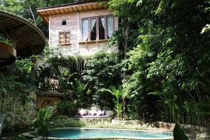 乌鲁瓦图Roots Tree House的一座带花园的房屋,设有游泳池