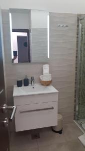 罗维尼AURA Residence的浴室设有白色水槽和镜子