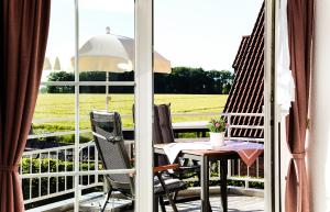 巴特塞森多夫Gästehaus Sam的阳台配有桌椅,享有田野美景。