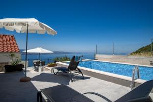 奥米什Villa Panorama的一个带椅子和遮阳伞的游泳池