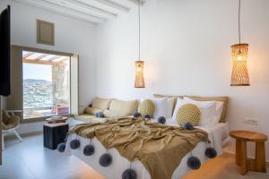 圣爱奥尼斯米科诺斯Due Mari Mykonos的一间卧室配有一张大床和一张沙发