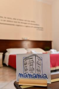 利帕里Mamamia Lipari的一张桌子上的标牌,放在一个有床的房间