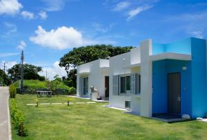 石垣岛石垣島北部一棟貸しコテージあちみぃん（achimiin）的蓝色和白色的房子,有院子