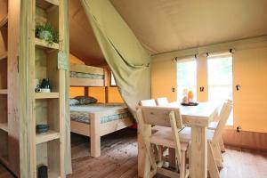 Tardets-SorholusTENTE SAFARI Lodge FERME CARRIQUE的帐篷内带桌子和床的房间