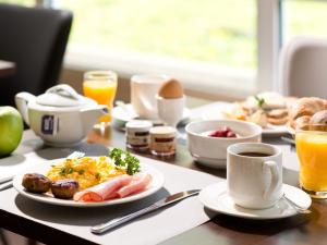 茨维考ACHAT Hotel Zwickau的一张桌子,上面有早餐食品和咖啡