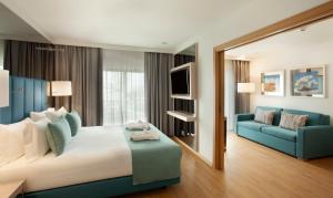 波尔蒂芒TURIM Presidente Hotel的酒店客房设有一张大床和一张蓝色的沙发。