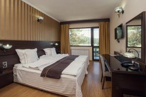 巴塔克Family Hotel Hebar的酒店客房设有一张大床和一张书桌。