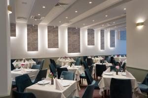 密古雷休治Hotel Fenyõ的餐厅设有白色的桌子和蓝色的椅子