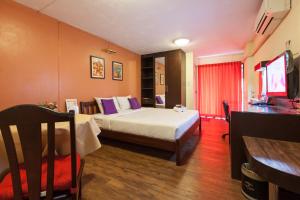 曼谷曼谷瓦布亚阿索特尔酒店的酒店客房,配有床和电视