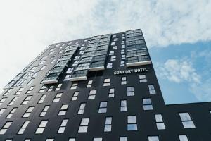 波多Comfort Hotel Bodø的一座高大的黑色建筑,上面有标志