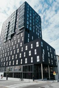 波多Comfort Hotel Bodø的一座黑色的大建筑,前面有一个人