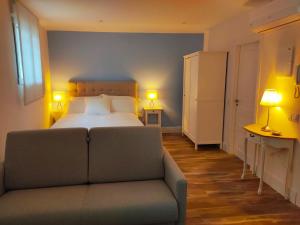 昆卡AT La casa Azul的一间卧室配有一张床、一张沙发和两盏灯。