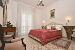 米诺利Casa Real的一间卧室配有一张带红色毯子和椅子的床