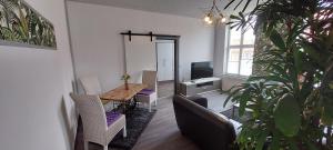 贝利茨Modernes wohnen im alten Beelitz Wohnung 2的客厅配有桌椅和电视。