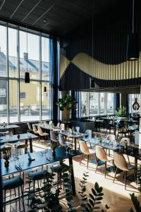 波多Comfort Hotel Bodø的餐厅设有桌椅和大窗户。
