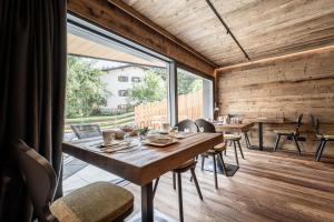 摩德纳迪-坎皮格里奥ALPINE DAYS Mountain Home的一间带桌子和大窗户的用餐室