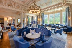 蓬特雷西纳克罗能霍夫大酒店的餐厅设有蓝色的桌椅和吊灯。