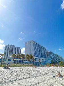 迈阿密海滩新起点迈阿密海滩公寓酒店的一群人躺在海滩上,有建筑