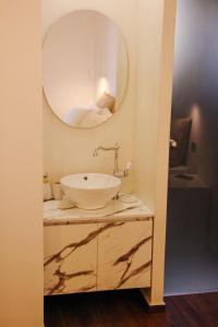 阿尔戈斯托利翁Polymnia Luxury Apartments Argostoli的一间带水槽和镜子的浴室