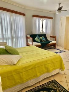 托雷斯Residencial Nápole的一间卧室配有一张黄色的大床和一张沙发