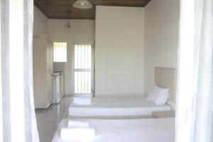拉加纳斯MARIA STUDIOS LAGANAS的白色墙壁和白色枕头的客房