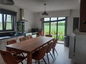 雷尼格尔斯特vakantiehuis zoetendaal的厨房配有大型木桌和椅子