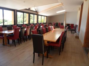 塞塞尔GITE AUBERGE EDELWEISS的一间会议室,配有木桌和红色椅子